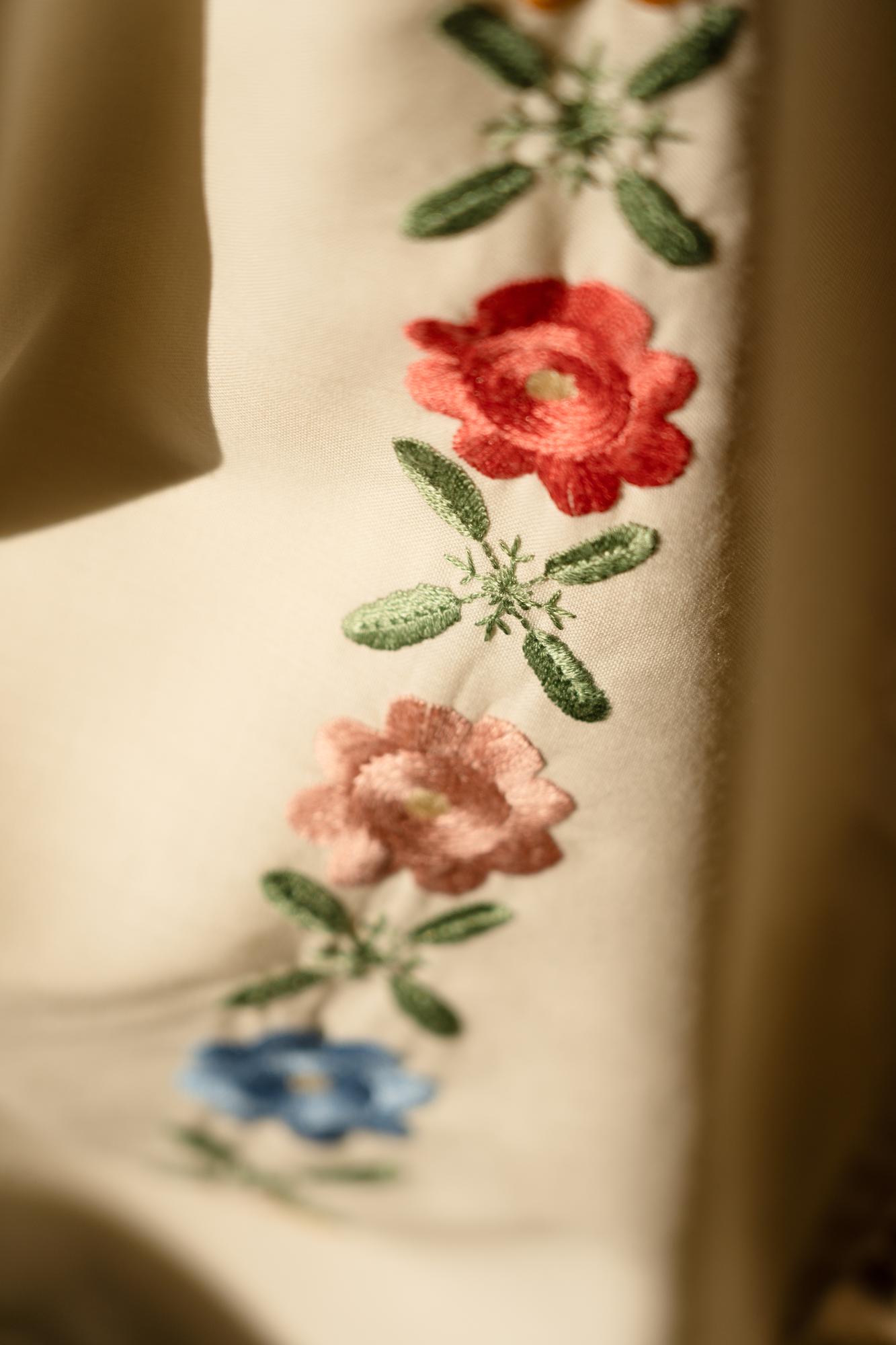 Stickerei Detail auf Leinen mit floraler Komposition
